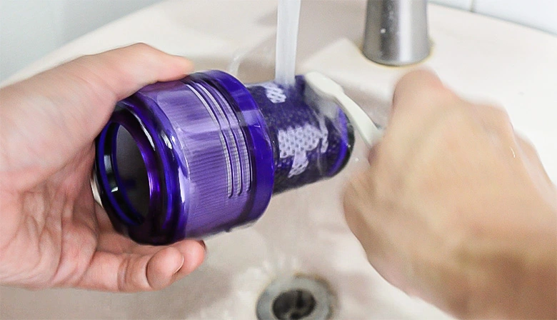 Cleaning Dyson V12 filter with water and toothbrush